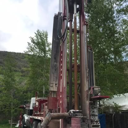 Drilling operation among green trees