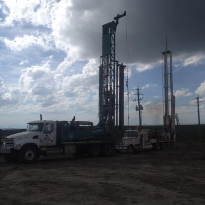 Dual drilling rigs under dramatic sky