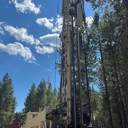 Tall drilling rig in forest setting