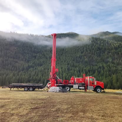 Red drilling truck with mountain mist