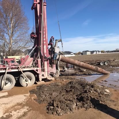 Red drilling rig in action pumping water