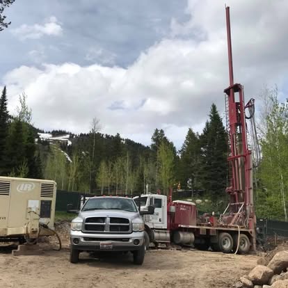 Mountain drilling site with support vehicles